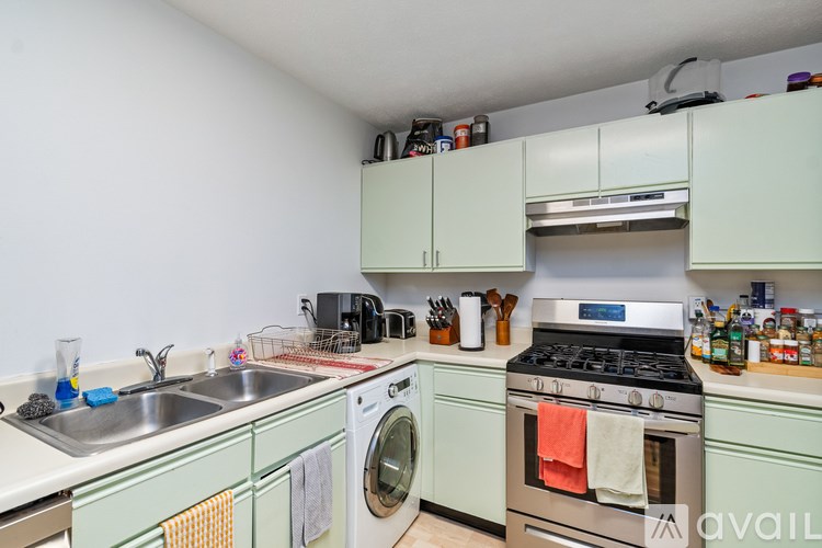 A kitchen with a washing machine, oven, and refrigerator.