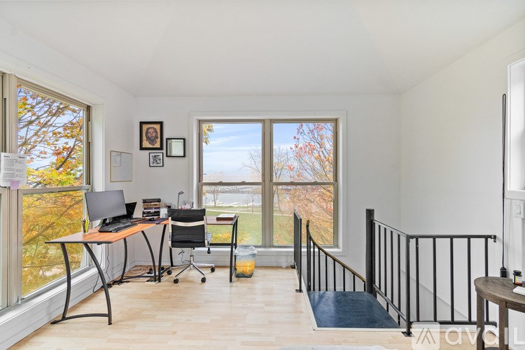 A long hallway with doors on the left and a staircase in the distance.