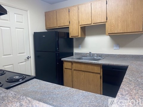 A kitchen with wooden cabinets and a black stove top oven.