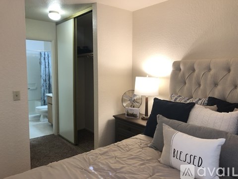 A bedroom with a bed, nightstand, and lamp.