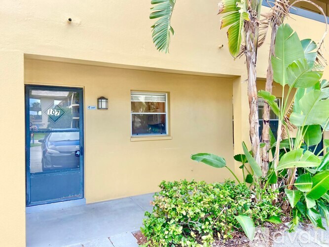 A yellow building with a blue door and window.