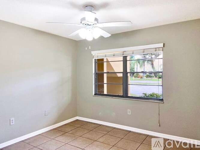 A room with a ceiling fan and a window.