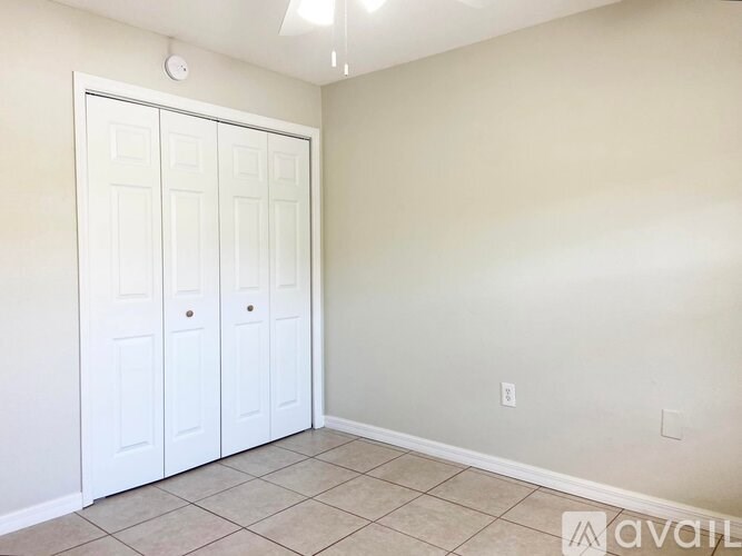 A room with a white door and tiled floor.