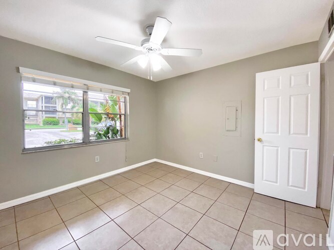 A room with a ceiling fan and a door.