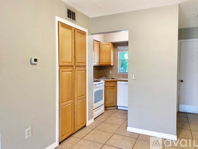 A kitchen with white appliances and wooden doors.