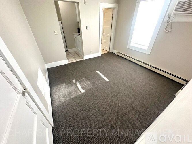 A room with a carpeted floor and white walls.