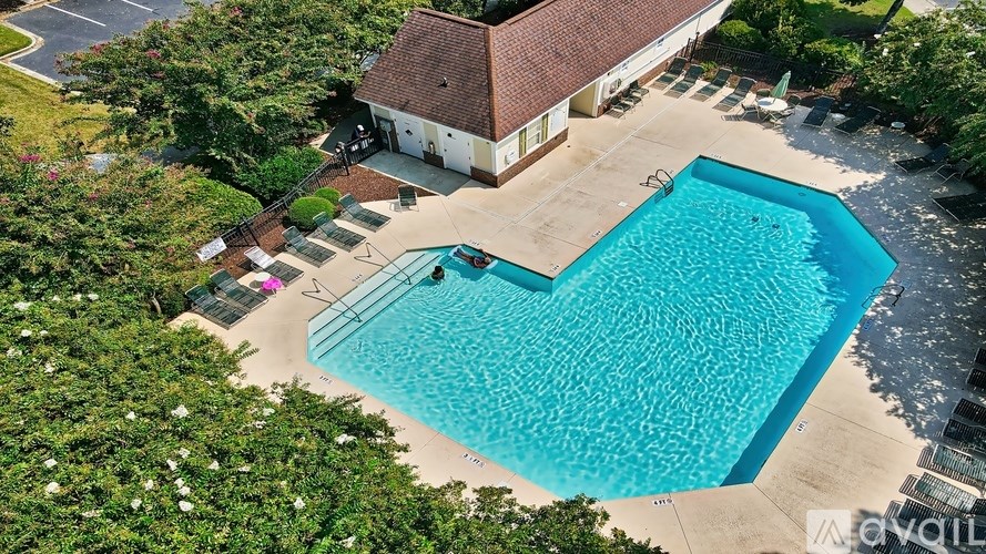 A heart-shaped pool is surrounded by a garden and a house.