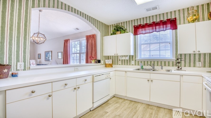 A kitchen with white cabinets and a striped wallpaper.