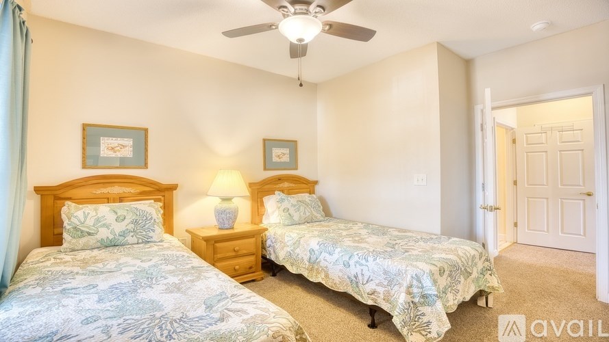 Two beds in a room with a ceiling fan.