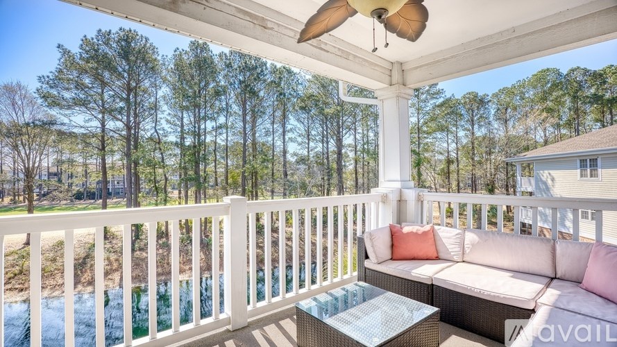 A white porch with a couch and a table.
