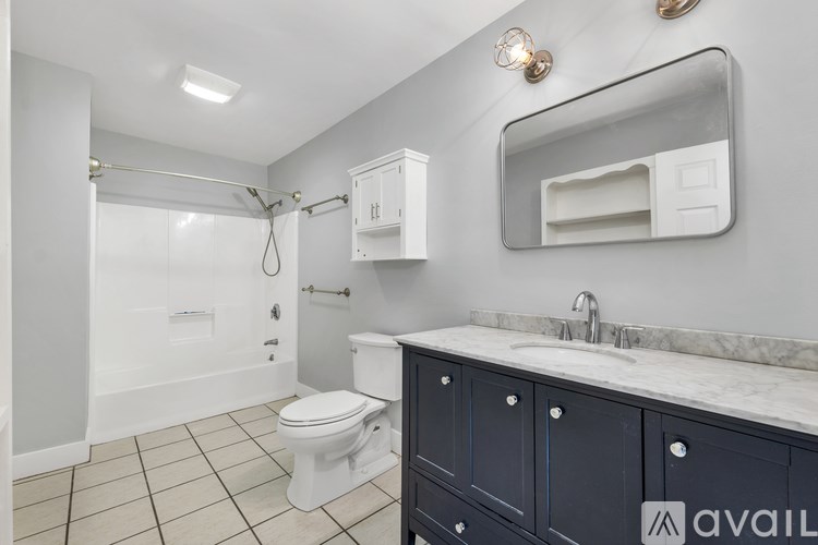 A bathroom with a toilet, sink, and mirror.