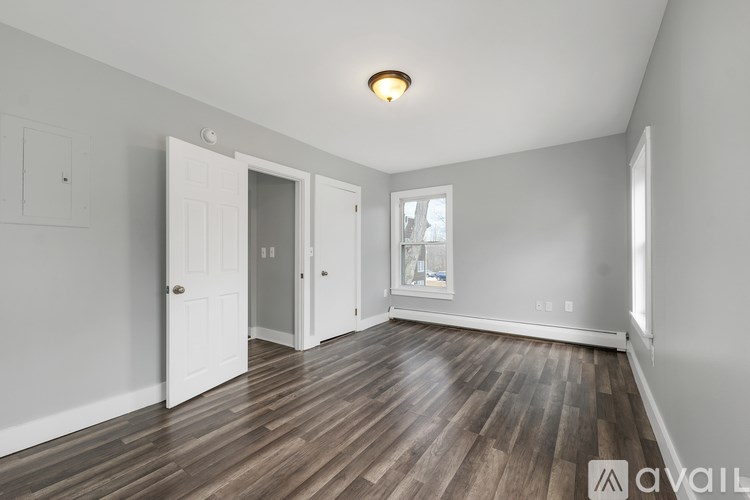 A room with wooden flooring and white walls.