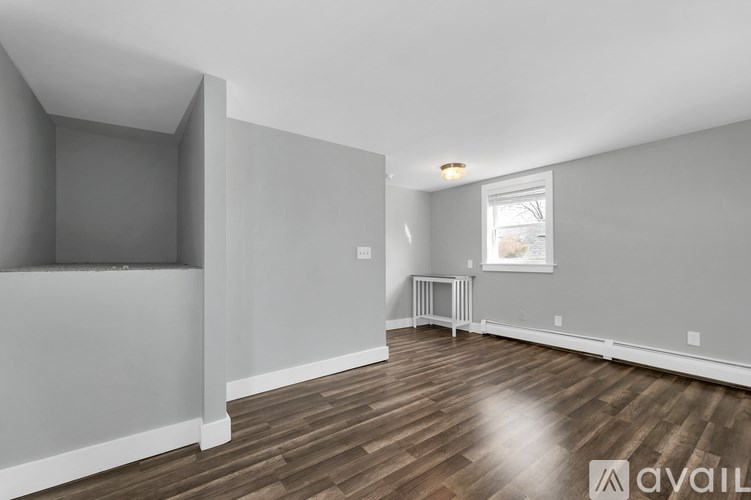 A room with wooden flooring and white walls is available for rent.