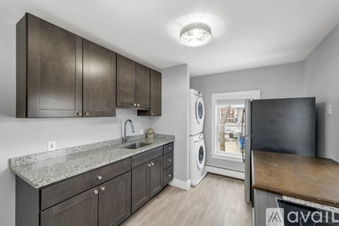 A kitchen with dark brown cabinets and a granite countertop.