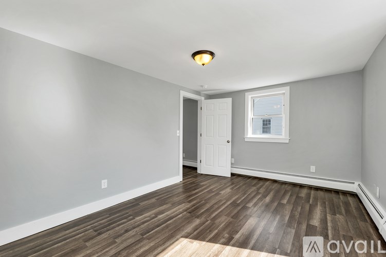 A room with wooden flooring and a white door.