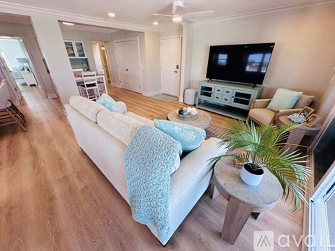 A living room with a white couch and a television.