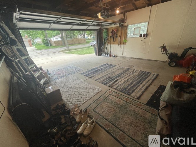 A garage with a car lift and shoes on the floor.