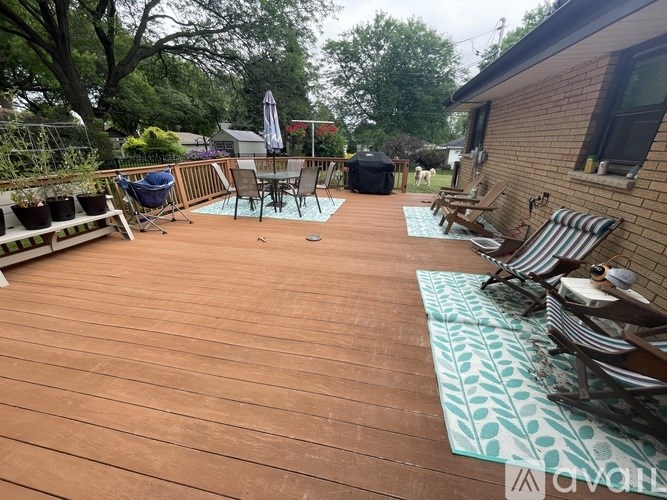 A wooden deck with chairs and a table.