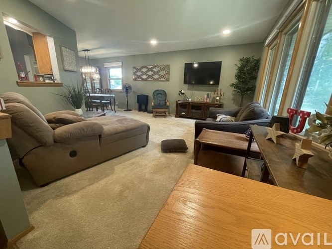 A living room with a couch, chair, and television.