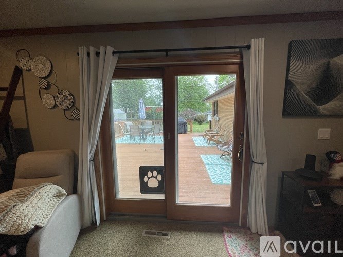 A room with a sliding glass door leading to a backyard.