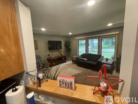 A living room with a black couch and a wooden coffee table.