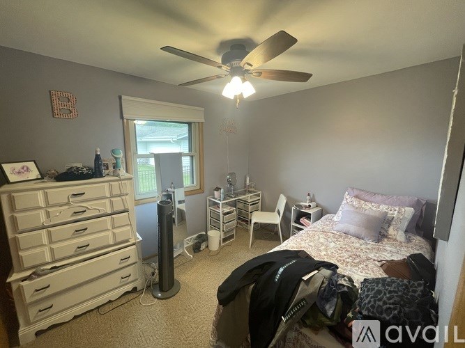 A bedroom with a bed, dresser, and window.