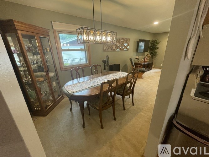 A dining room with a round table and chairs.