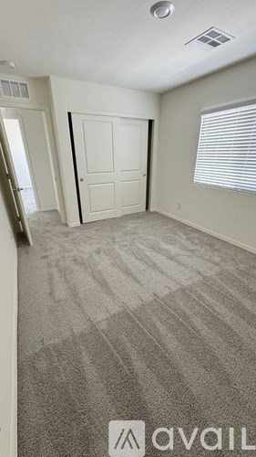 A room with a carpeted floor and a white door.