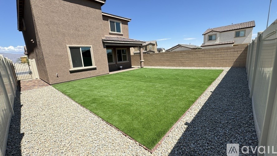 A house with a brown exterior and a green lawn in front.