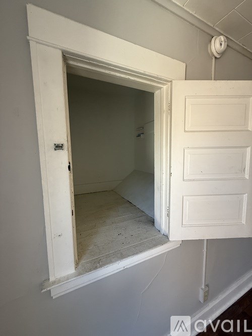 A white door is open to a room with a white ceiling.