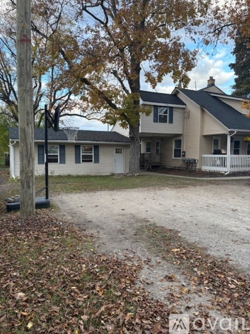 A house with a white fence and a tree in front.