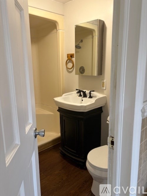 A bathroom with a white sink and a white toilet.