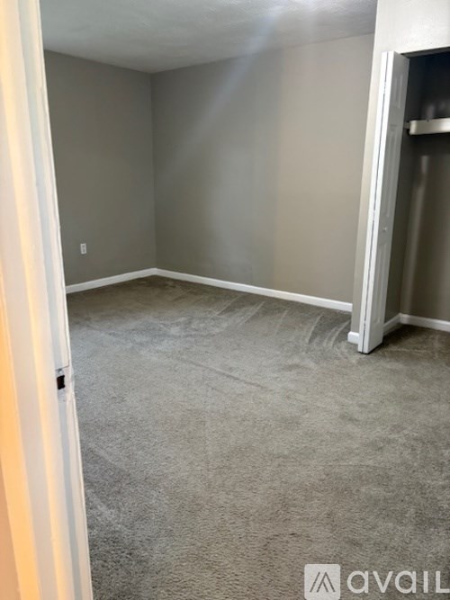 A room with a carpeted floor and a white door.