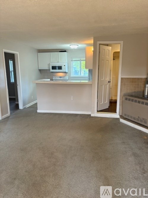 A kitchen area with a microwave, oven, and cabinets.
