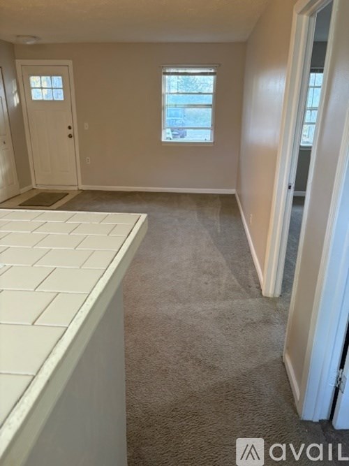 A room with a carpeted floor and a window.