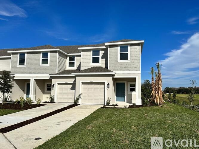 A modern house with a grey exterior and a white garage door.