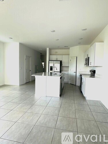 A kitchen with white cabinets and a tiled floor.