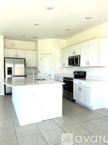 A kitchen with white cabinets and appliances.