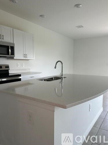 A kitchen with white cabinets and a white countertop.