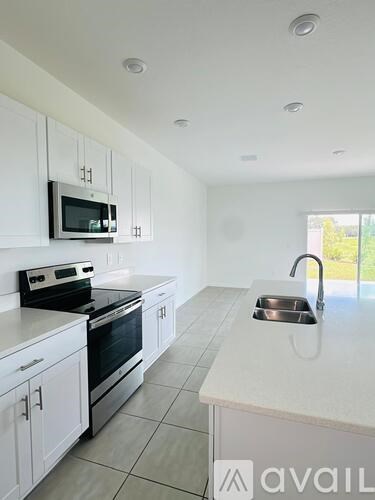 A kitchen with white cabinets and appliances.