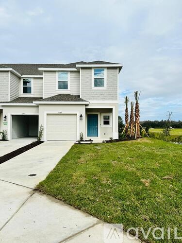A two-story house with a garage and a blue door.