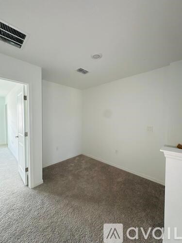 A room with a carpeted floor and a white door.