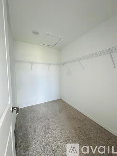 A room with a carpeted floor and a wall-mounted shelf.