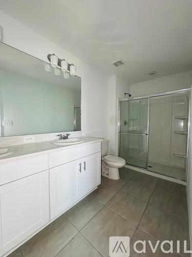 A bathroom with a sink, toilet, and shower.