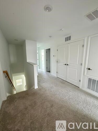 A carpeted hallway with white walls and a logo that reads "avaiL".