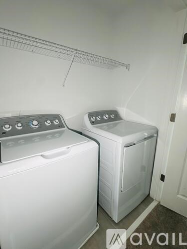 Two white front loading washing machines in a laundry room.