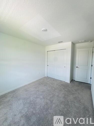 A room with two doors and a carpeted floor.