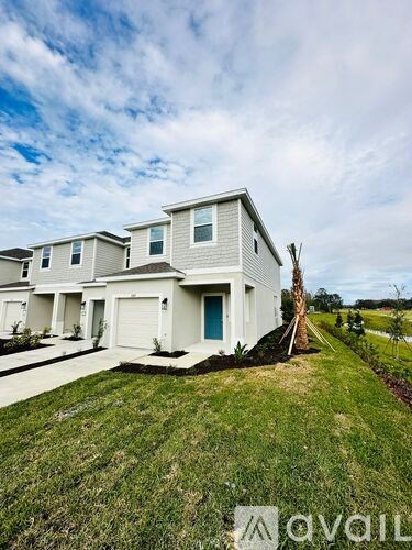 A white house with a blue door is for sale.