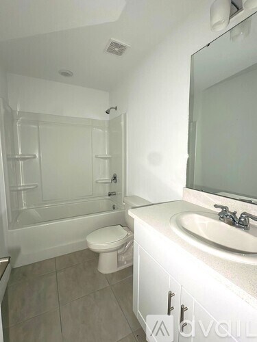 A white bathroom with a toilet, sink, and shower.
