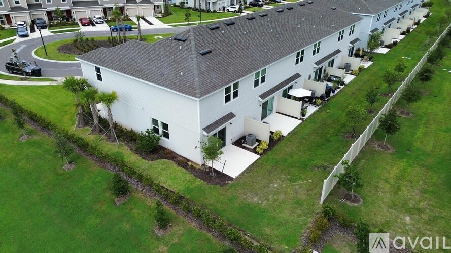 A white building with a grey roof is surrounded by green grass.